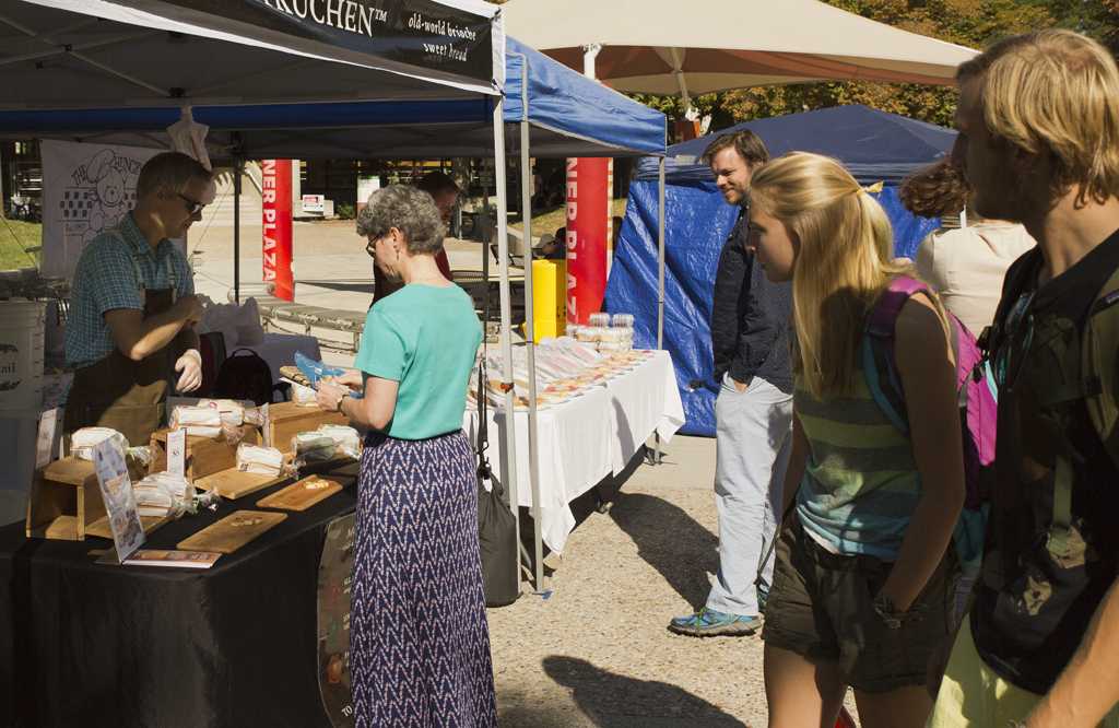 Students pass by the first farmers market of the school year at Tanner Plaza, Thursday August 27, 2015.