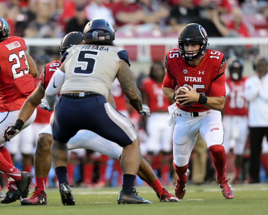 Utah freshman, Chase Hansen (15), runs the ball past the Aggies defense; The Utah Utes beat the Utah State Aggies 24-14 at Rice Eccles Stadium on Friday, September 11, 2015