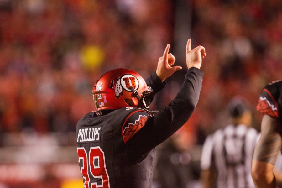 Kicker Andy Phillips (39) throws up a U infront of the MUSS after making a field goal.