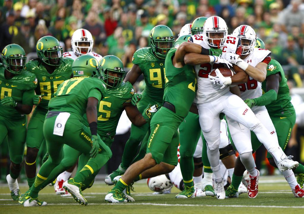 Senior running back Devontae Booker (23) tries to shed tacklers in a Pac-12 football game against the Oregon Ducks at Autzen Stadium in Eugene, Ore., Saturday, Sept. 26, 2015. Mike Sheehan, Daily Utah Chronicle.