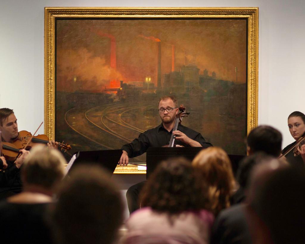 The U graduate string quartet performs in front of Lionel Walden's "Steelworks, Cardiff, at Night" 1895-97, at Pastures Green & Dark Satanic Mills: The British Passion for Landscape exhibit at the Utah Museum of Fine Arts, Wednesday, September 2, 2015. Mike Sheehan, Daily Utah Chronicle.