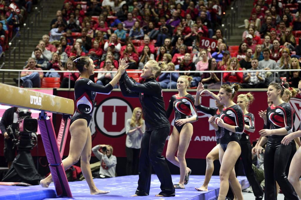 Senior Kailah Delaney is congratulated by her team after her bar routine ina meet against the Arizona Wildcats at the Jon M. Huntsman Center on Monday, Feb. 1, 2016. (Kiffer Creveling, Daily Utah Chronicle)