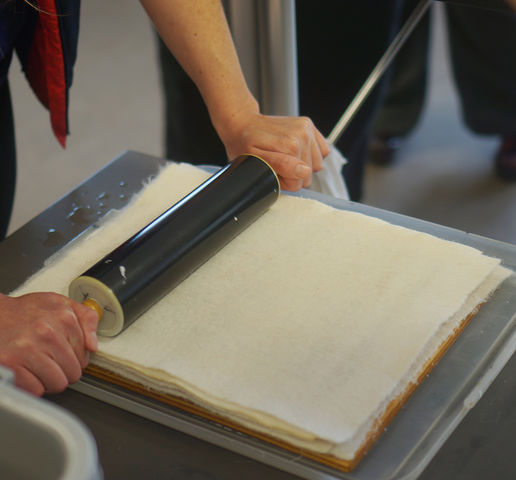 A rolling pin dries the pulp - now between two sheets of felt - that is used to create the paper at the U Book Arts Workshop on Friday, April 15, 2016. (Rishi Deka, Daily Utah Chronicle)