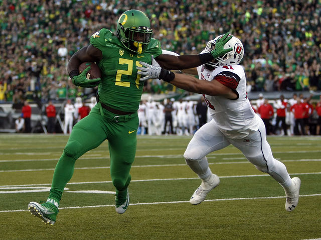 Oregon Ducks running back Royce Freeman (21) stiff-arms Utah linebacker Jarred Norris (41) as he reaches the end zone in the first half against the Utah Utes in Pac-12 action at Autzen Stadium in Eugene, Ore., Saturday, Sept. 26, 2015.