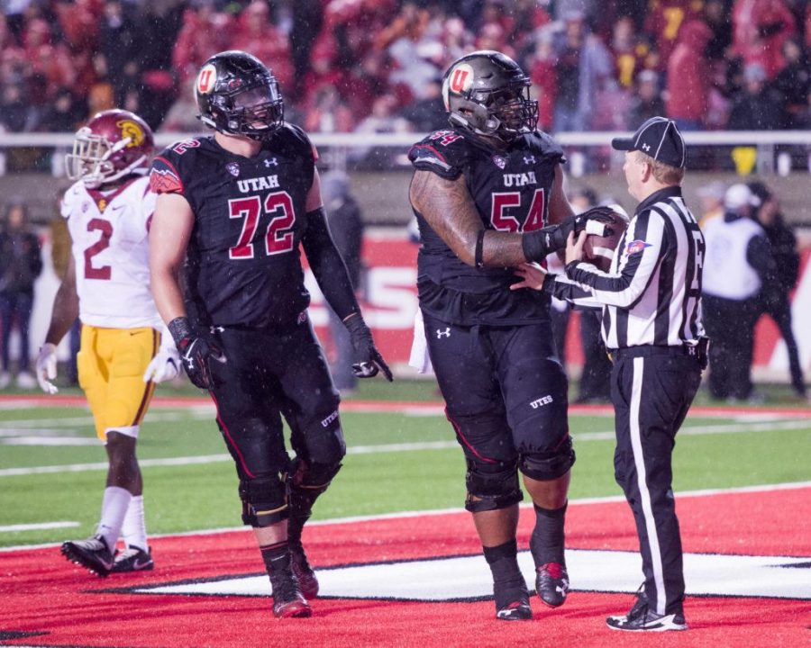 University of Utah Football senior senior left guard Isaac Asiata (54) hands the ball to the ref after the touchdown during the game vs. the University of Southern California Trojans at Rice-Eccles Stadium on Friday, September 23, 2016