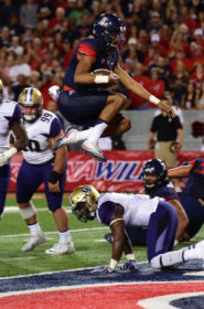 Rebecca Noble / The Daily Wildcat : Arizona quarterback Brandon Dawkins (13) leaps into the end zone for one of his several touchdowns of the night during Arizona's overtime 35-28 loss to Washington in Arizona Stadium on Saturday, Sept. 24.