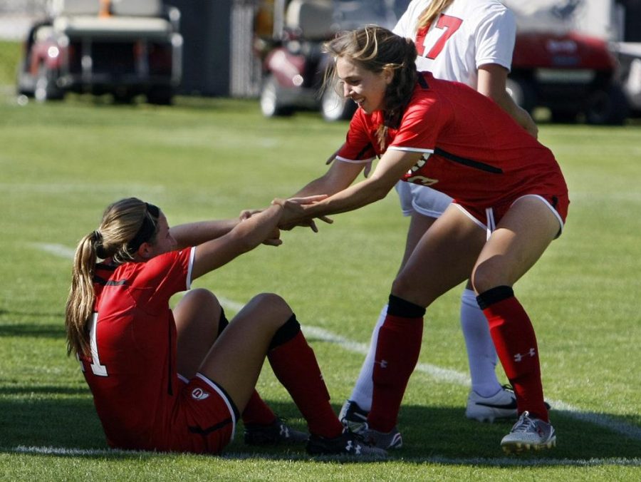 Freshman midfielder Max Flom (11) is helped up by teammate, junior midfielder Katie Rogers (3), after Flom scores a goal at the home opener of Utah soccer against the Houston Cougars at Ute Field, Friday, August 28, 2015.