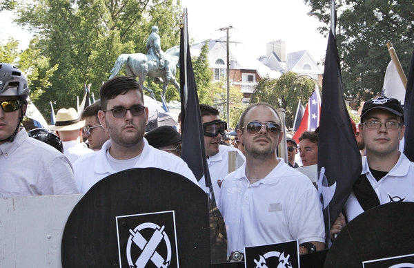 James Alex Fields Jr., left, marches in a white nationalist rally on Saturday, Aug. 12, 2017 wearing apparel and holding a shield associated with the American fascism group Vanguard America. Fields is charged with driving a car into a group of counterprotesters, killing one and injuring 19. 