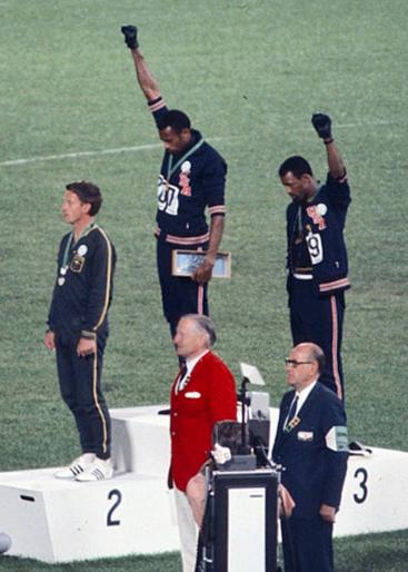 Olympics medalists Tommie Smith and John Carlos raise their fists in protest against the United States. 