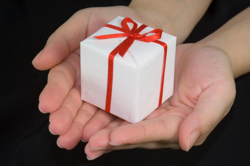 Hands+holding+a+gift+box+isolated+on+black+background