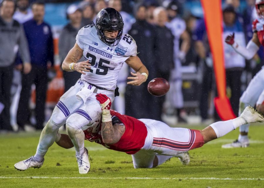 Northwestern University freshman running back Isaiah Bowser (25) fumbles the ball after getting tackled by University of Utah junior defensive end Bradlee Anae (6) during the San Diego County Credit Union Holiday Bowl at SDCCU Stadium in San Diego, California on Monday, Dec. 31, 2018. (Photo by Kiffer Creveling | The Daily Utah Chronicle)