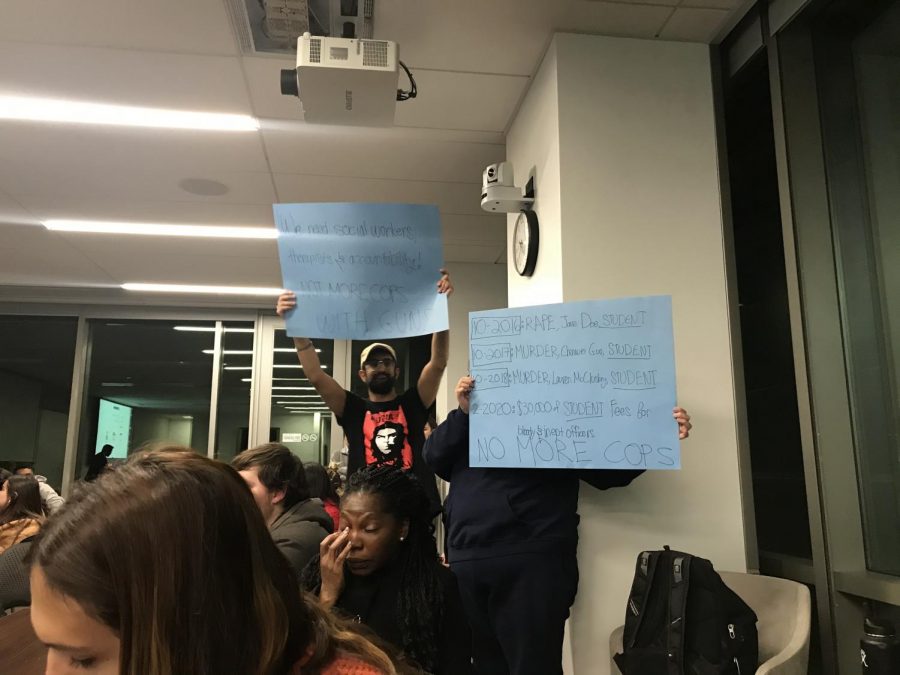 Students hold up signs saying “no more cops at the hearing for Joint Bill 4. S.J. Quinney Law School, Feb. 27. (Photo by Natalie Colby | Daily Utah Chronicle)