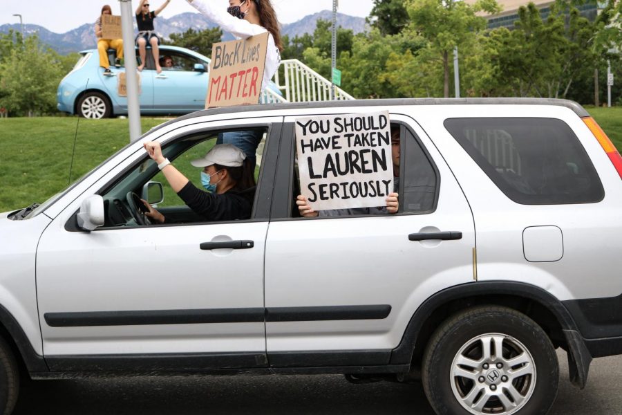 Nina, 22, holds sign in solidarity for Lauren McCluskey in caravan protest on June 6, 2020 after the police  scandal which revealed an officer involved in McCluskeys case showed intimated photographs.