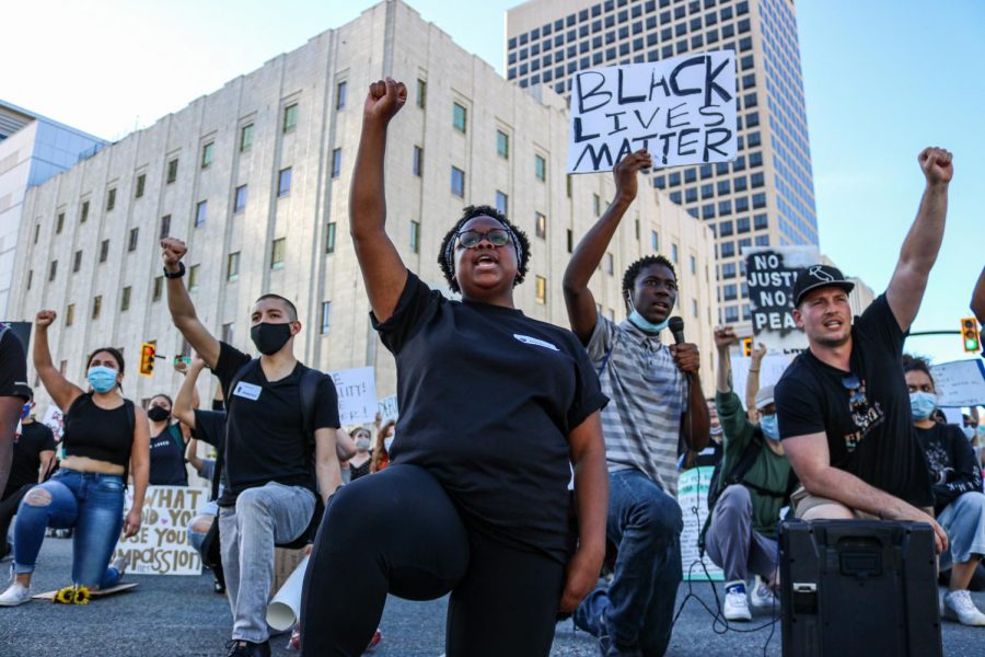 Grace Cunningham and Ammon Roberts take a knee with fellow protestors after marching from the state capitol to the Wallace Bennett Federal Building in solidarity with the Black Lives Matter movement on June 9, 2020. (Photo by Ivana Martinez | Daily Utah Chronicle)