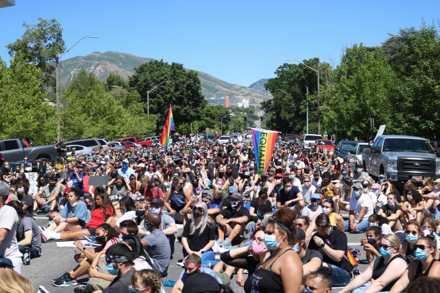 Protestors sit on Salt Lake City streets outside the Public Safety Building listening to organizers speak at the Juneteenth protest. (Photo by Ivana Martinez | Daily Utah Chronicle)