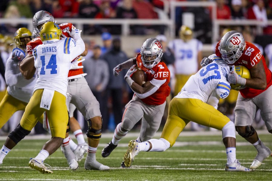 University of Utah senior running back Zack Moss (2) rushes with the ball after taking a handoff from University of Utah senior quarterback Tyler Huntley (1) in an NCAA Football game vs. UCLA at Rice-Eccles Stadium in Salt Lake City, UT on Saturday November 16, 2019.(Photo by Curtis Lin | Daily Utah Chronicle)
