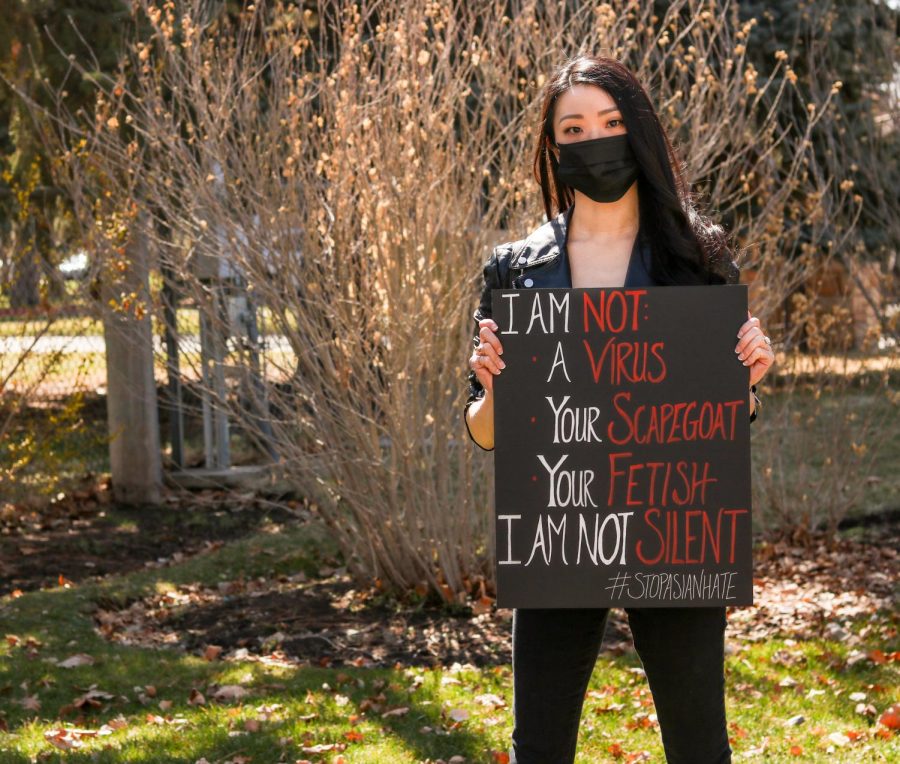 Amanda Lee holds up poster. During the Trump Adminstration there was political rhethoric linking the COVID-19 virus to Asian Americans communities. (Photo by Ivana Martinez | Daily Utah Chronicle)