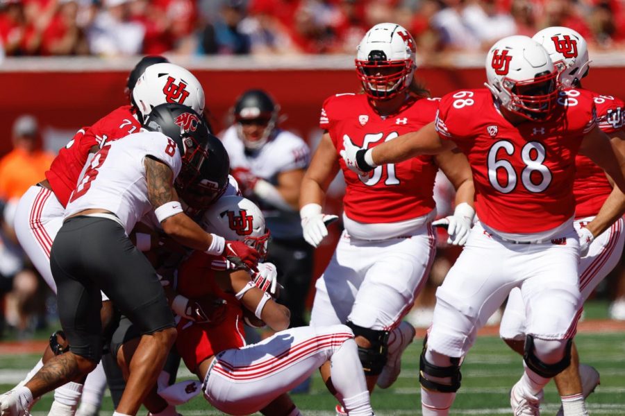 University of Utah running back Micah Bernard is tackled in the game against the Washington State Cougars at Rice-Eccles Stadium. (Photo by Jonathan Wang | The Daily Utah Chronicle)