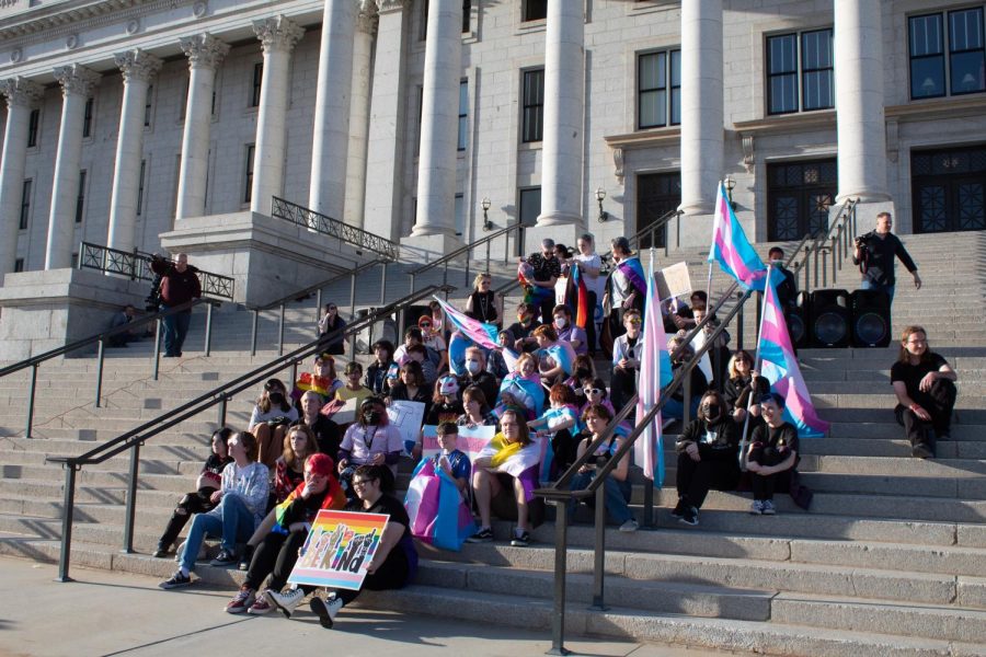 Transgender youth sit on the steps at the Utah State Capitol on March 24, 2022 as the crowd surrounding them chanted We love you. (Photo by Carlene Coombs | Daily Utah Chronicle)