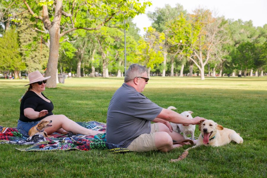 A couple rests under the shade with their dogs at the Liberty Park, Salt Lake City, Utah on June 17, 2022. (Photo by Amen Koutowogbe | The Daily Utah Chronicle)