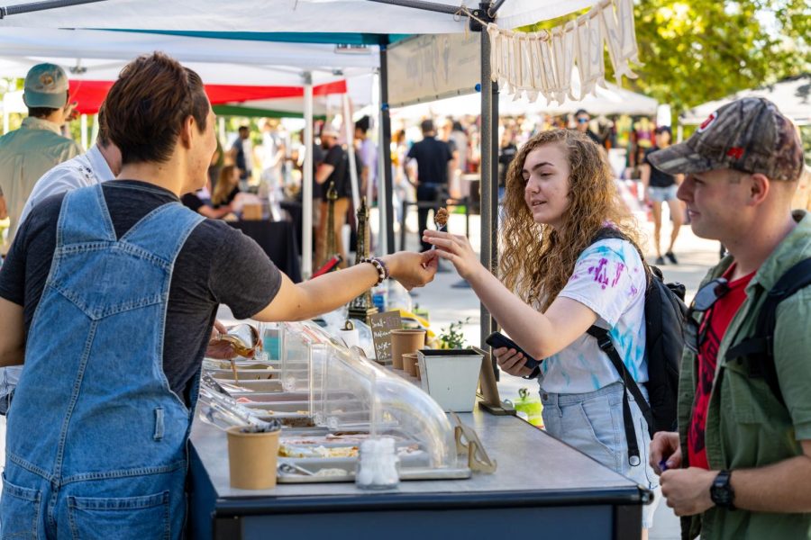 A student gets a scoop of ice cream at the farmers market at Tanner Plaza on the University of Utah campus in Salt Lake City, Utah on Aug. 25, 2022. (Photo by Xiangyao Axe Tang | The Daily Utah Chronicle)