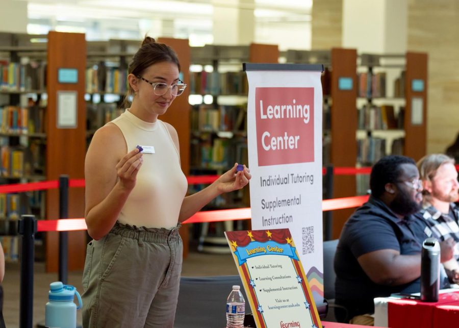 Casey Hoekstra, associate director of the learning center, speaks to students about opportunities in the learning center at the Hooplaza event which took place at the Mariott Library on campus on Sept. 8, 2022. The library's many resources are on display on the third floor for students to find out more about how they can better use their library. (Photo by Jack Gambassi | The Daily Utah Chronicle)