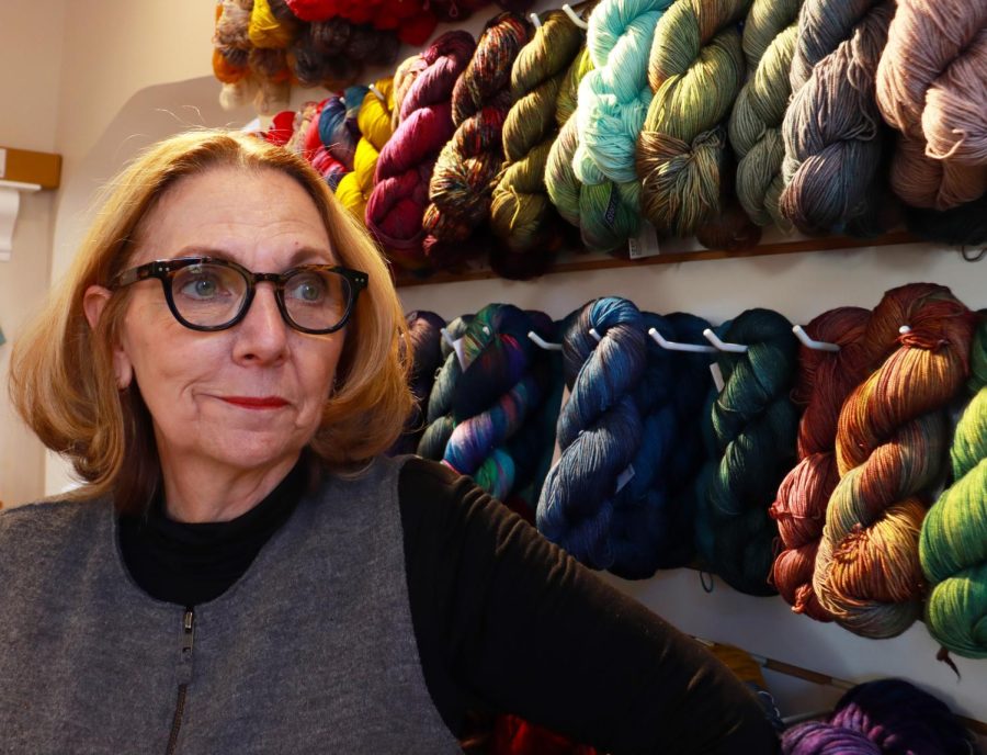 Cynthia Mills, owner of Blazing Needles in Salt Lake City, Utah, takes a moment away from customers to stand with a yarn display on Nov. 23, 2022.