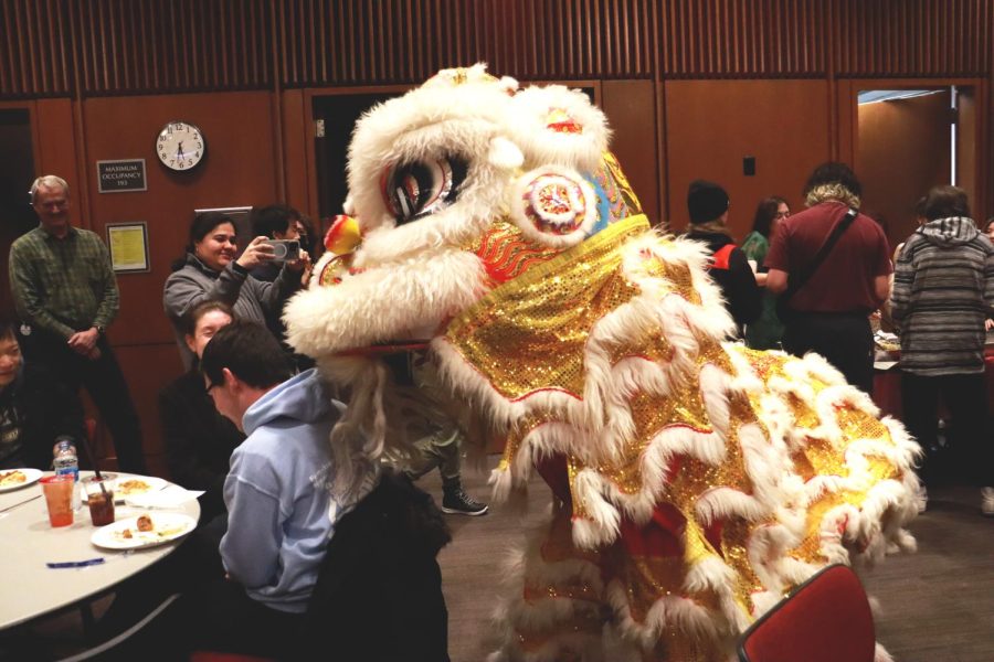Dragon dancers Harold Truong (head) and Emilio Camu (legs) play with visitors by nudging their heads and shoulders at the Lunar New Year Social at the Mariotte Library in Salt Lake City, Utah on Friday, Jan. 20, 2023. (Photo by Sarah Karr | The Daily Utah Chronicle)