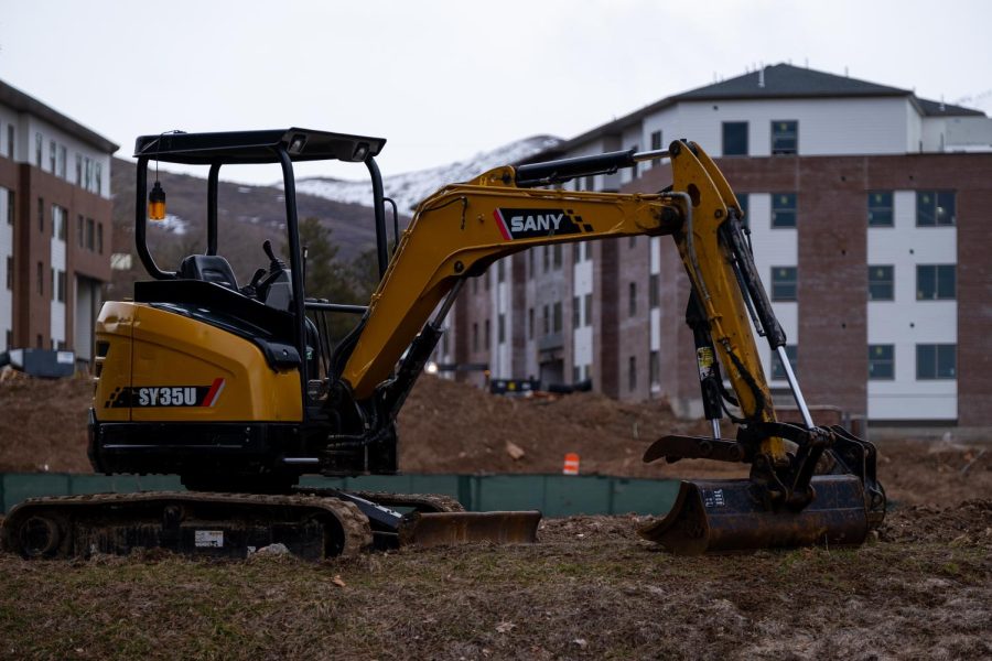 A mini excavator in front of the new West Village housing under construction in Salt Lake City on Wednesday, Mar. 22, 2023. (Photo by Marco Lozzi | The Daily Utah Chronicle)