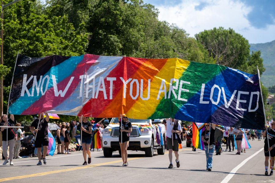 Parade participants carrying a banner that reads Know that you are loved during the 2023 Utah Pride Parade in downtown Salt Lake City on Sunday, June 4, 2023. (Photo by Marco Lozzi | The Daily Utah Chronicle)
