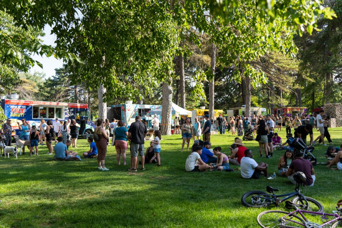 People sitting on the lawn at the Food Truck Face Off at Liberty Park in Salt Lake City on Saturday, July 8, 2023. (Photo by Xiangyao Axe Tang | The Daily Utah Chronicle)