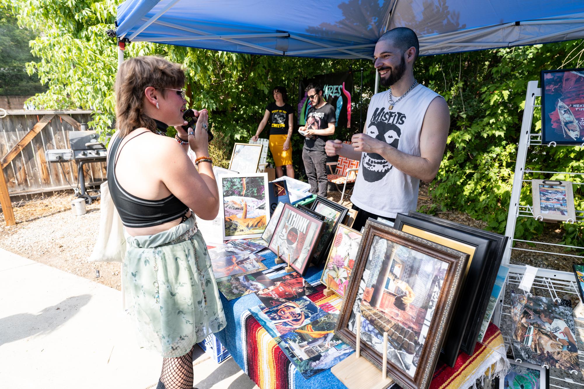 Cameron Lara talks to a customer at the SLC Punk Rock Flea Market at the Lost Acorn Gallery in Salt Lake City on July 30, 2023. (Photo by Xiangyao "Axe" Tang | The Daily Utah Chronicle)