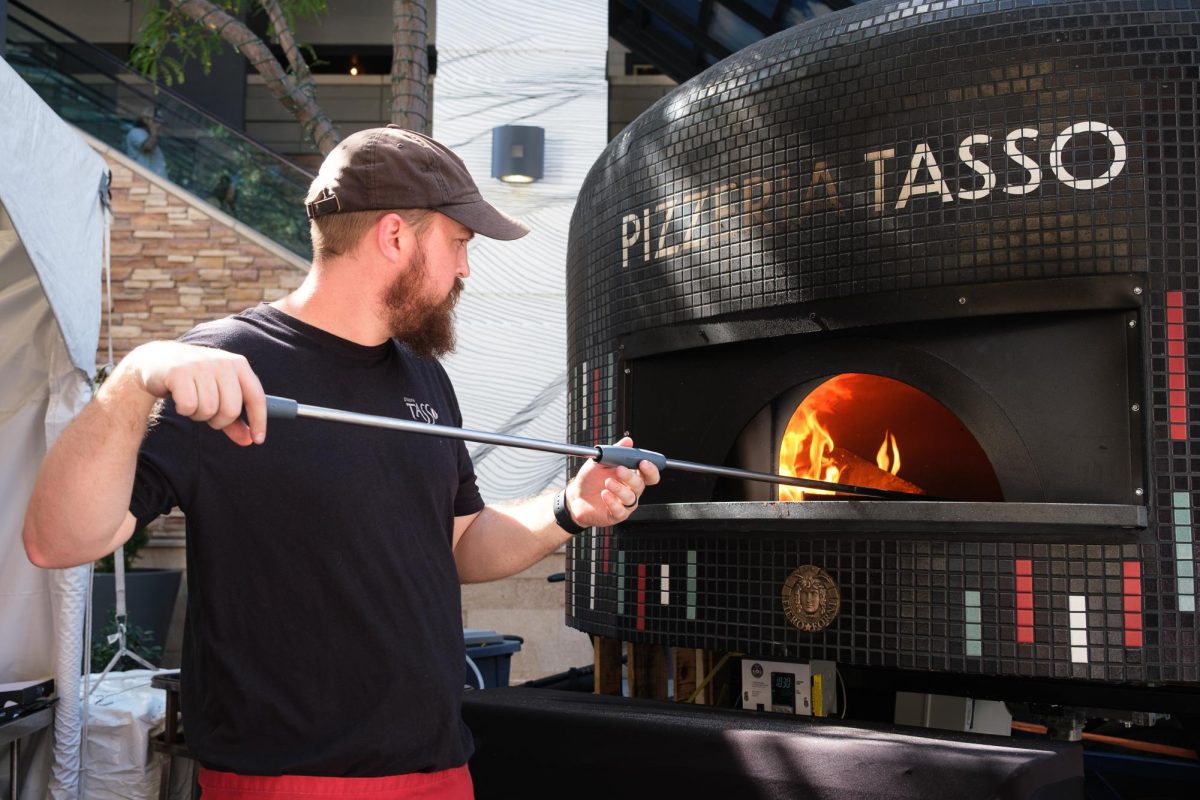 A Pizzeria Tasso chef slides a pizza into a wood-fired oven at Festa Italiana in Salt Lake City on Sunday, Sept. 17, 2023. (Photo by Marco Lozzi | The Daily Utah Chronicle)