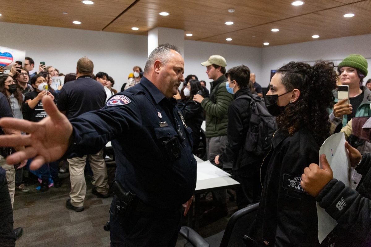A police officer asks a demonstrator to leave at the Young Americans for Freedom at the University of Utah’s watch party in J. Willard Marriott Library in Salt Lake City on Wednesday, Nov. 01, 2023. (Photo by Xiangyao “Axe” Tang | The Daily Utah Chronicle)