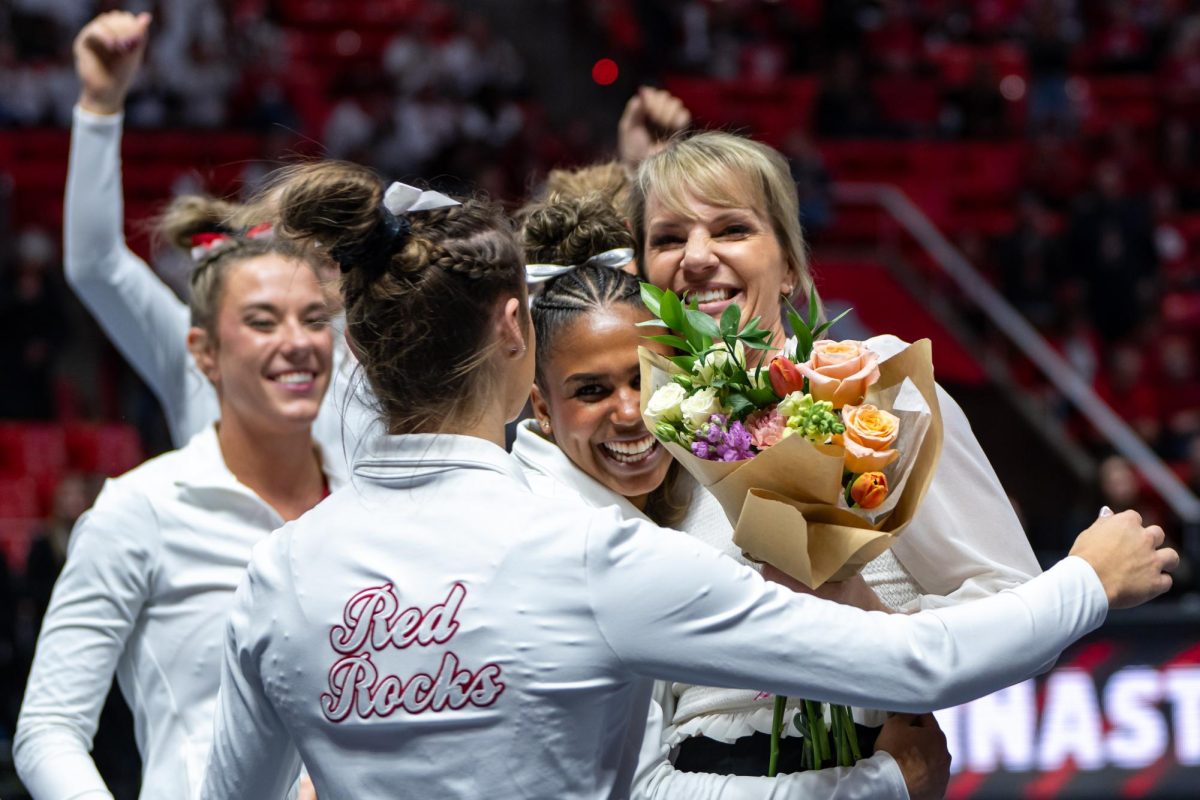 The Utah Red Rocks’ head coach Carly Dockendorf and gymnasts after defeating the Boise State Broncos at the Jon M. Huntsman Center in Salt Lake City on Friday, Jan. 5, 2024. (Photo by Xiangyao “Axe” Tang | The Daily Utah Chronicle)