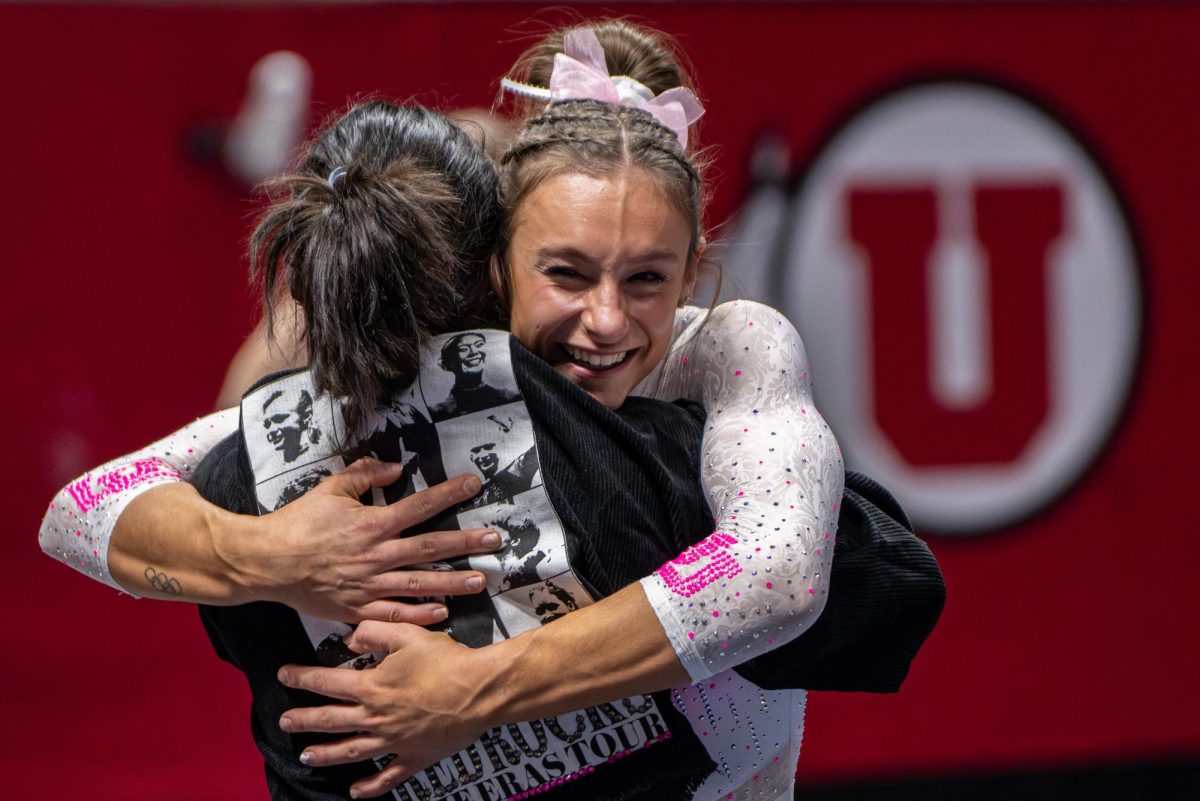Utah gymnast Grace McCallum embraces assistant coach Myia Hambrick after scoring a perfect 10 on her floor routine versus the Stanford Cardinal at the Jon M. Huntsman Center in Salt Lake City on Feb. 23, 2024. (Photo by Xiangyao “Axe” Tang | The Daily Utah Chronicle)