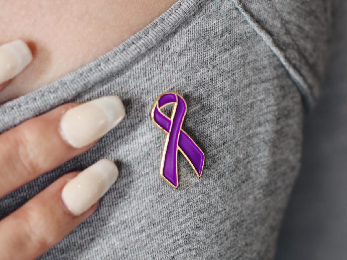Bailey McGartland points to her domestic violence awareness pin in the Alpha Chi Omega Sorority house by the University of Utah campus in Salt Lake City on Feb. 9, 2024. (Photo by Rachel Kloepfer | The Daily Utah Chronicle) 
