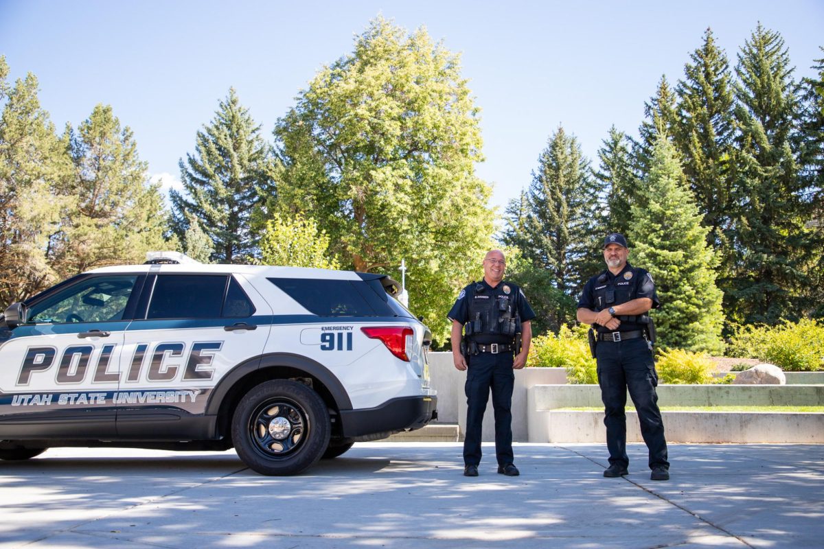 Brad Hansen, left, and Shane Nebeker stand in front of a USU police car. (Photo by Heidi Bingham)