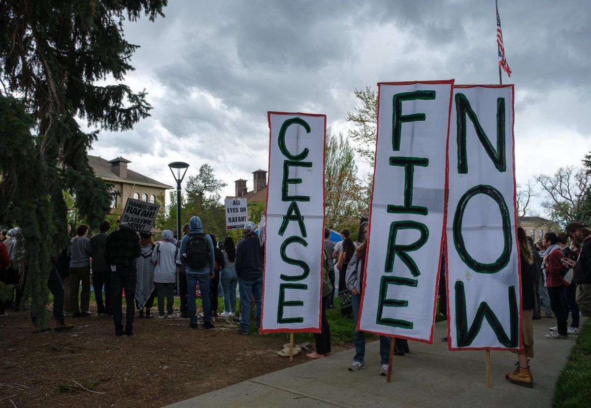 Pro-Palestine demonstrators hold up signs that read Cease Fire Now next to the newly built encampment in front of the John R. Park Building at the University of Utah during the Emergency Rally For Palestine on Monday, April 29, 2024. (Photo by Marco Lozzi | The Daily Utah Chronicle)