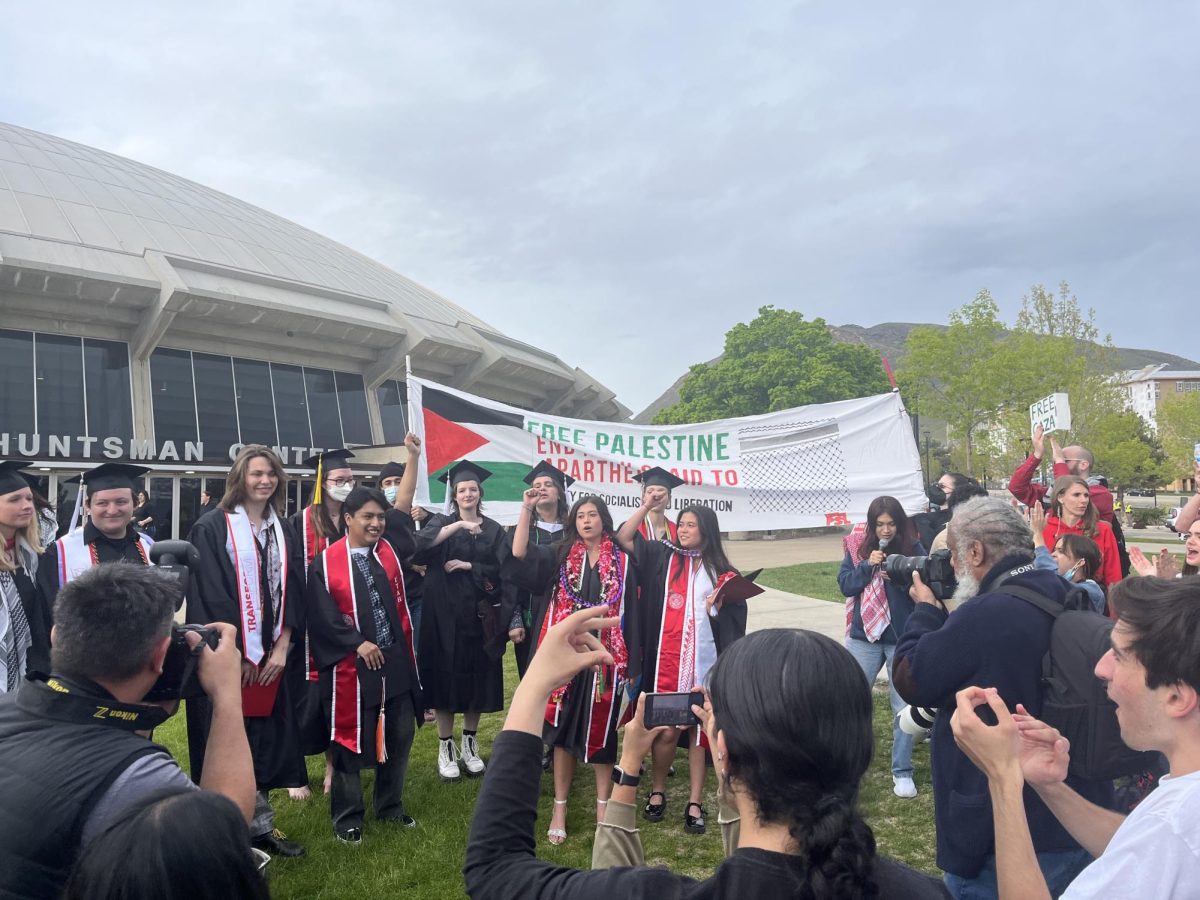 Graduates receive applause from demonstrators outside the Jon M. Huntsman Center on the University of Utah campus in Salt Lake City. (Photo by Emerson Hagy | Daily Utah Chronicle)