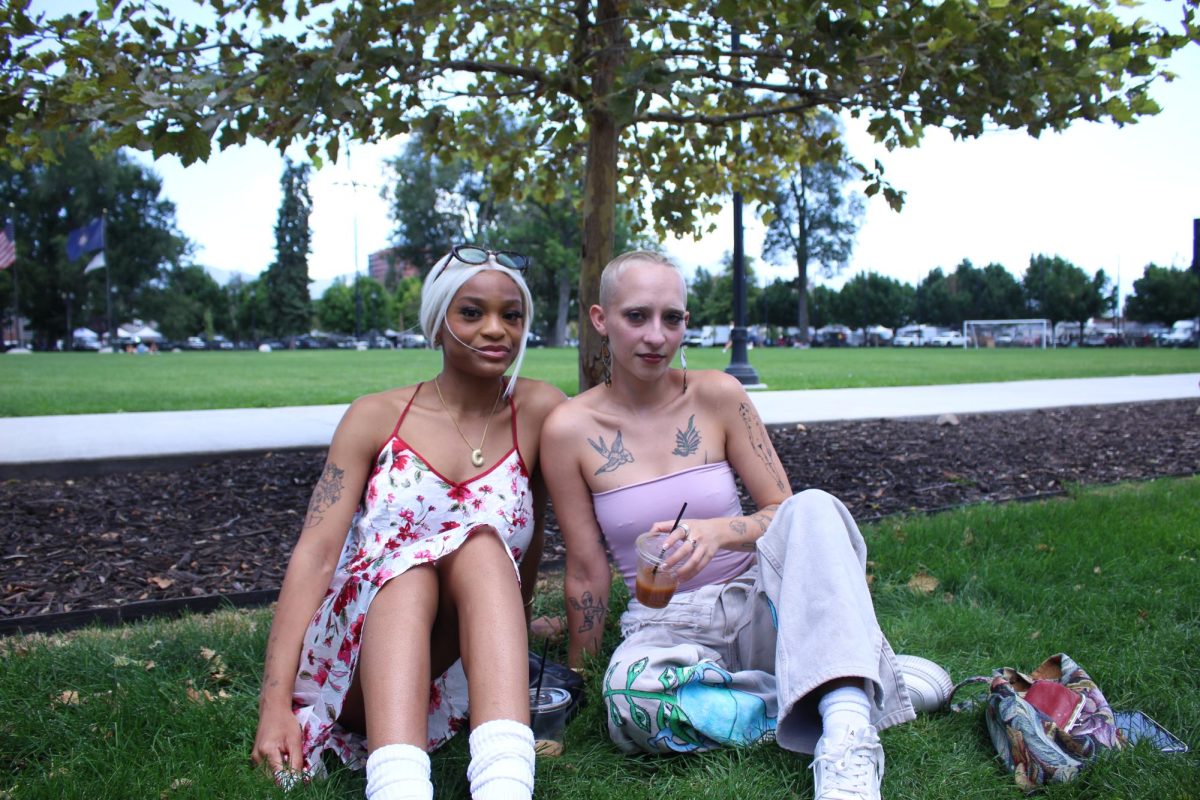 Two individuals pose in their cute outfits. (Photo by Hailey Edmonds | The Daily Utah Chronicle)