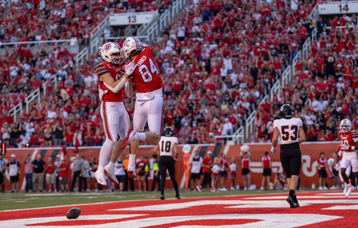 University of Utah tight ends Brant Kuithe (80) and Caleb Lohner (84) celebrating a touchdown versus Southern Utah University at Rice-Eccles Stadium in Salt Lake City on Aug. 29, 2024. (Photo by Samantha Lazenby | The Daily Utah Chronicle)