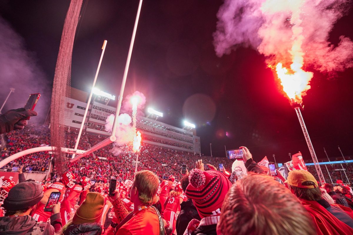 The Utah Utes football team of the University of Utah run onto the field accompanied by flares and fireworks curtesy of the 801 Pyros in the Rice-Eccles Stadium during the U vs. BYU game on Saturday, Nov. 9, 2024. (Photo by Luke Larsen | The Daily Utah Chronicle)