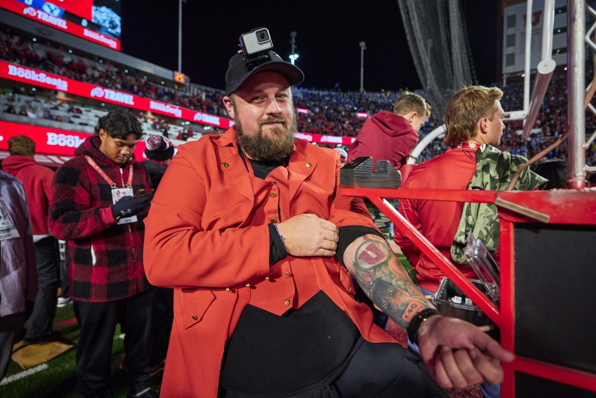 Brady Gabbitas poses to show his tattoo commemorating his time in the 801 Pyros before the run on of the Utah Utes during the U vs. BYU game in the Rice-Eccles Stadium on Saturday, Nov. 9, 2024. (Photo by Luke Larsen | The Daily Utah Chronicle)