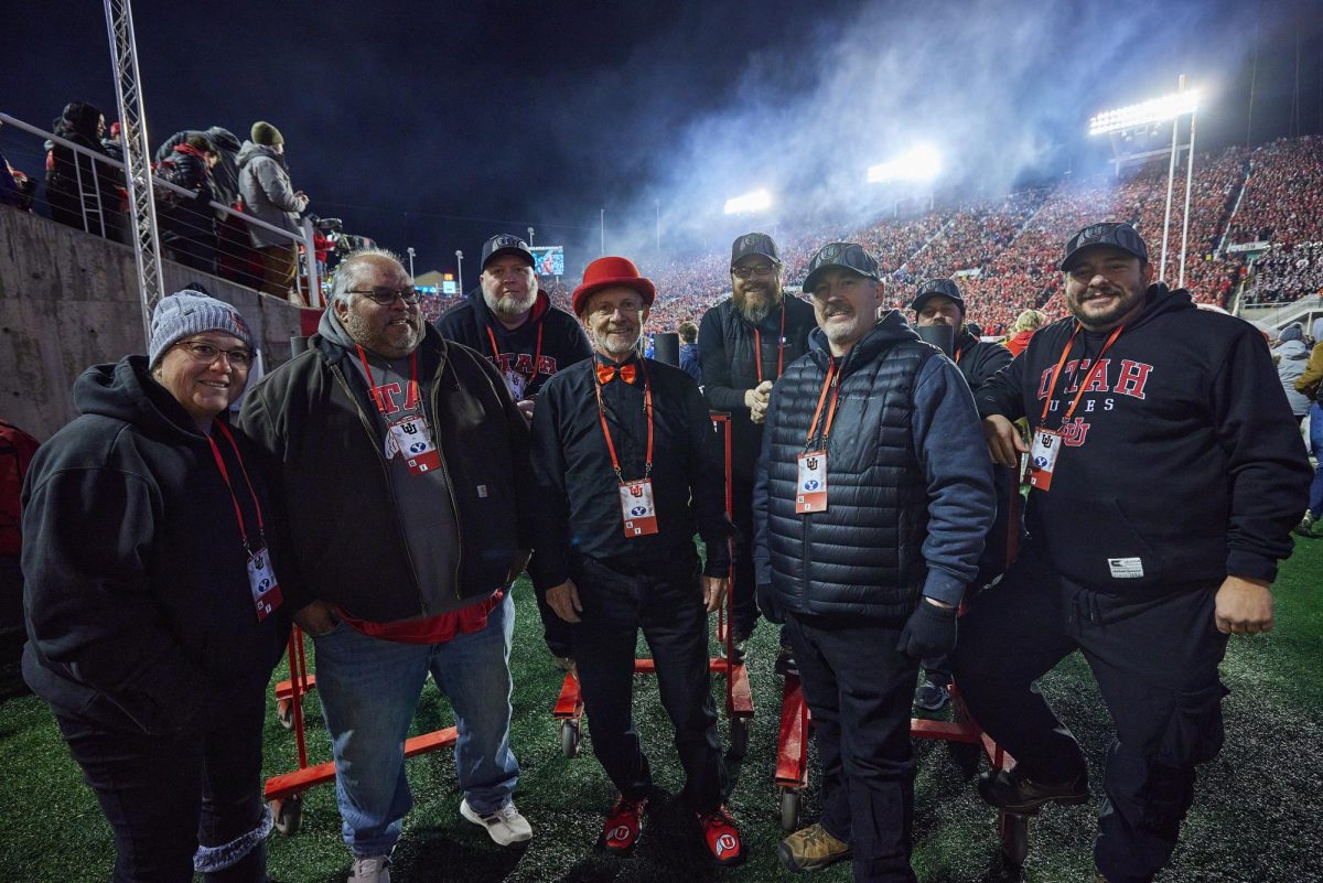 The 801 pyros, pyrotechnicians for University of Utah sporting events founded by Chuck Johnson (center), pose for a portrait during the U vs. BYU game in the Rice-Eccles Stadium on Saturday, Nov. 9, 2024. (Photo by Luke Larsen | The Daily Utah Chronicle)