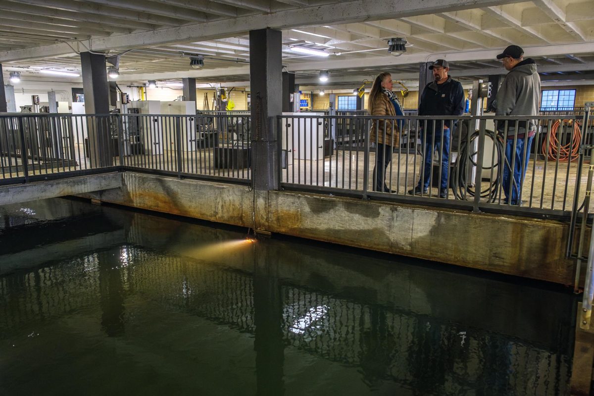 From left, Teresa Gray, Dustin Gilgen and Russ Ranck converse by the flocculation basin at the Big Cottonwood Water Treatment Plant in Cottonwood Heights, Utah, on Tuesday, Dec. 10, 2024. During flocculation, one of the first steps in water treatment, large paddlewheels mix the water after ferric chloride is added to coagulate any solid particles. “We’re trying to settle out as much as we can before we get into our filter building,” said Ranck, water treatment facility manager at the Big Cottonwood Water Treatment Plant. (Photo by Marco Lozzi | The Daily Utah Chronicle)