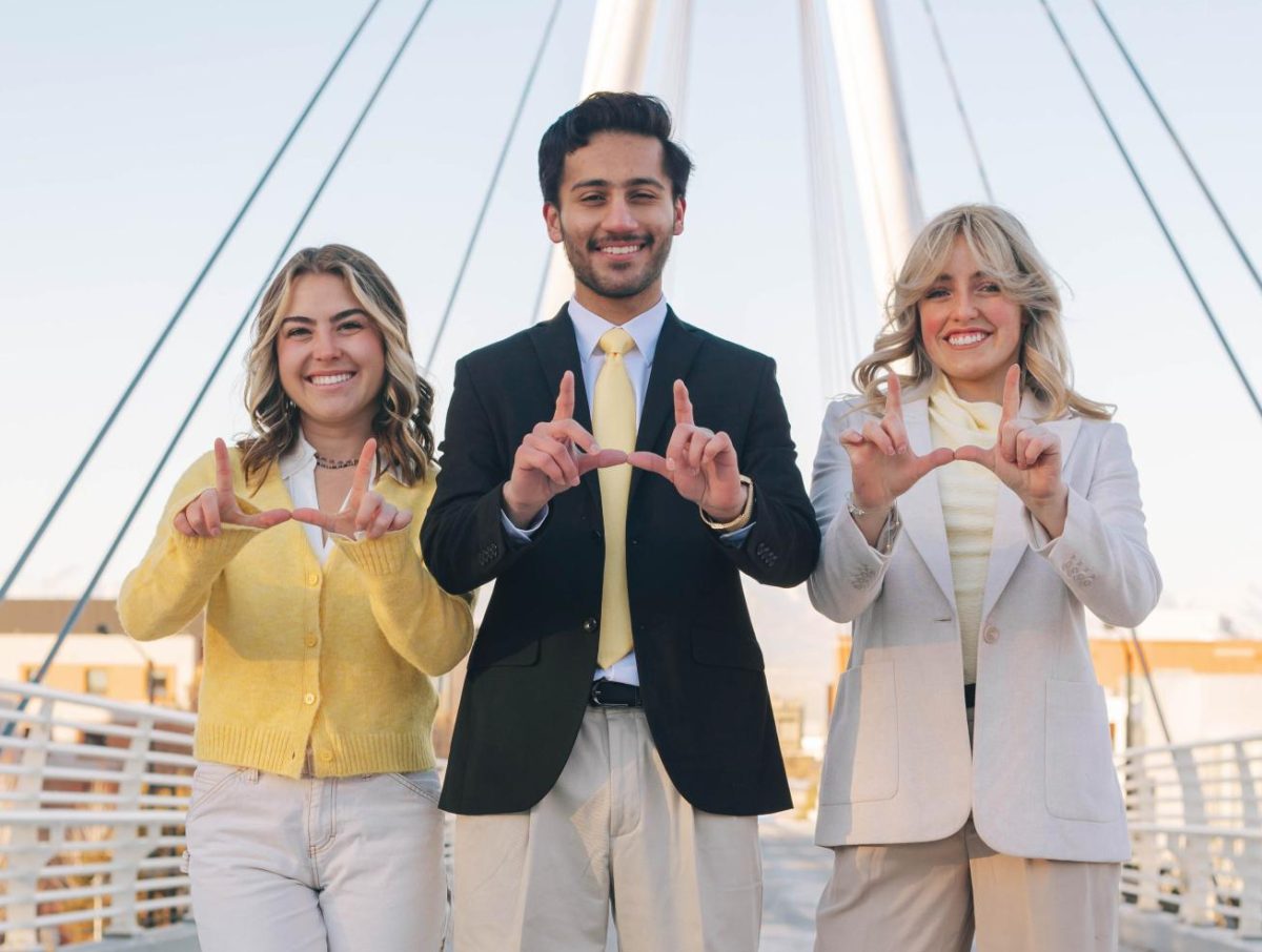 From left to right: Olivia Saenz, Sunny Singh and Elle Williams flash the U on the Legacy Bridge (Photo curtesy of the Singh ticket). 