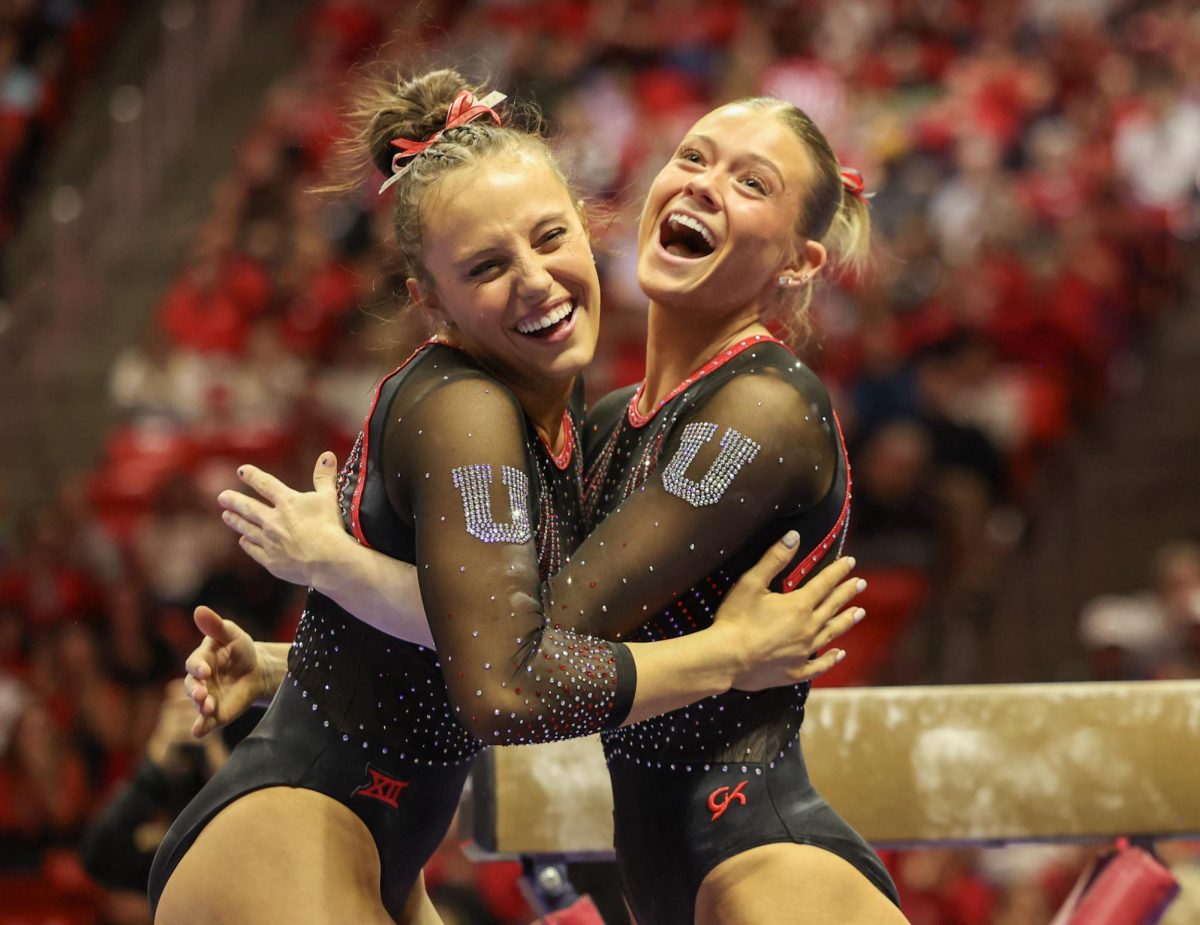 Utah junior Ella Zirbes (left) celebrates with teammate Avery Neff following Zirbes beam routine at the tri-meet against Minnesota and Iowa at the Jon M. Huntsman Center on Friday, Jan. 2, 2026. (Photo by Sean Stetson | The Daily Utah Chronicle)