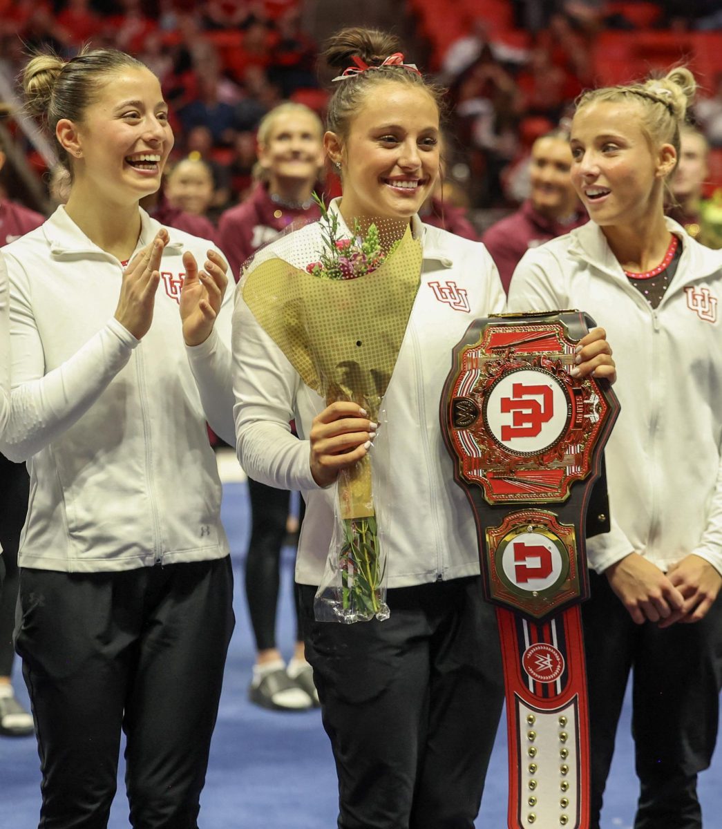 Utah junior Ella Zirbes celebrates after the Red Rocks’ win over Minnesota and Iowa, holding flowers and the WWE University of Utah Gymnastics Belt, at the Jon M. Huntsman Center on Friday, Jan. 2, 2026. (Photo by Sean Stetson | The Daily Utah Chronicle)