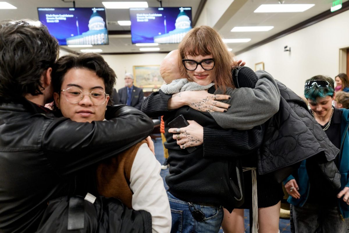 Benjamin and Cyrus Espiritu, left, and Michael Massimi and his daughter Blaire celebrate after HB 193 failed in the Senate Business and Labor Standing Committee, at the Capitol in Salt Lake City on Thursday, Feb. 19, 2026. The bill would have banned government entities from using public funds to pay for insurance coverage for transgender employees who receive hormonal treatments or sex characteristic surgical procedures. (Photo by Spenser Heaps for Utah News Dispatch)